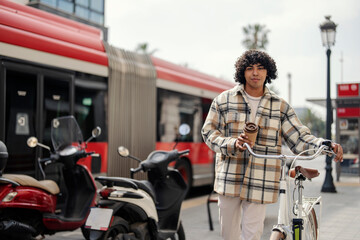 Obraz premium An urban traveler is pushing his bike on the streets of Barcelona during his vacation.