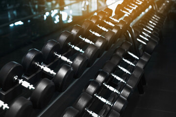 Black dumbbell set. Close up many metal dumbbells on rack in sport fitness center , Weight Training...
