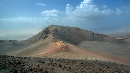View of volcanic landscape in Valle del Silencio, Valley of Silence in Timanfaya National Park in Lanzarote, Canary Islands, Spain