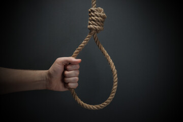 Hand holding Lynch rope loop on gray background