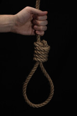 Rope noose of lynch for hanging in hand on black background