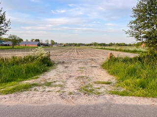 Experience the rustic charm of a plowed field merging with sandy textures, revealing a captivating...