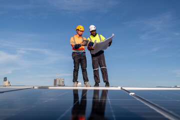 Engineers walking on roof inspect check and Maintenace solar cell panel by hold blue print  ,solar...