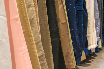 line up pants of different colors in the market. hanging on a rack. a  row of pants. concept of buying, selling, shopping, and fashion. stock images, selective focus. vienna, austria, 16 may 2023