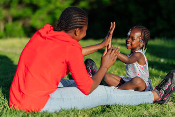 Fototapeta premium Happy little girl and her mother playing in the park