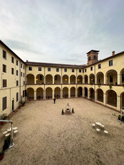 Fototapeta premium inner courtyard of ancient monastery with tables. Parma area, Italy