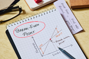 Notepad with the presentation of Break Even Point (BEP) on desk. Business analysis and cost...
