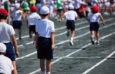 小学校の運動会で短距離走をしている学生達の後ろ姿