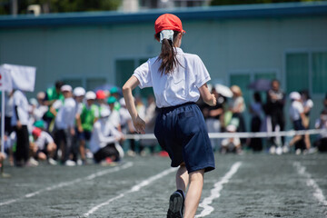 Obraz na płótnie Canvas 小学校の運動会で短距離走をしている女子生徒