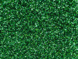 Dark green holographic glitter texture. Design pattern of sparkling shiny glitter.