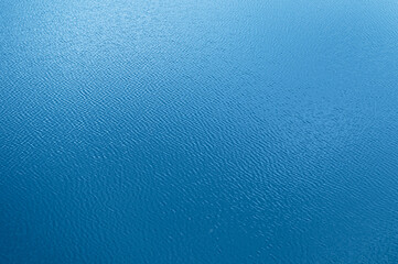 Fototapeta na wymiar Water surface. Blue water background with soft waves. Texture of the water surface.