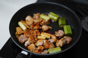 	鶏肉とネギをたれで煮詰める様子