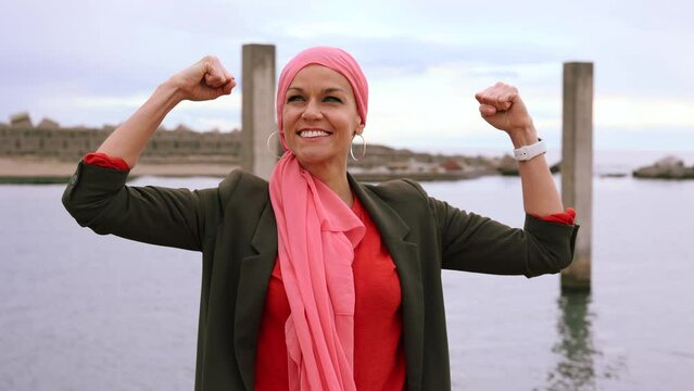 Strong mature woman with mantra scarf in the city with breast cancer awareness, cancer survivor fighter