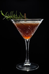 Alcoholic cocktail Cosmopolitan cocktail decorated with rosemary on martini glass on black background. Copy Space. 