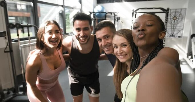 Group of fit people taking selfie in a gym