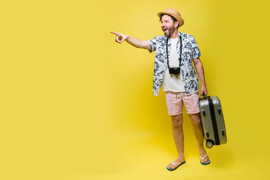 Happy excited man carrying his suitcase during his summer travel vacations