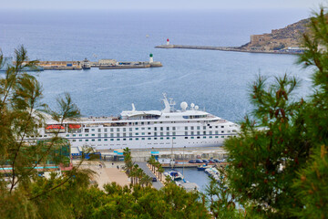 A cruise ship stands in port next to yachts and a warship. Cartagena, Spain. © Anna Baranova