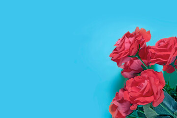Bouquet of red roses on a blue background. Place for text.