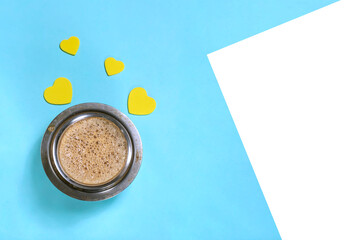 Filter Coffee cup and yellow paper hearts on blue background, top view