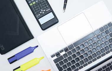flat lay photo showing calculator, financial figures, highlighter and laptop. Concept showing financial analysis or accounting