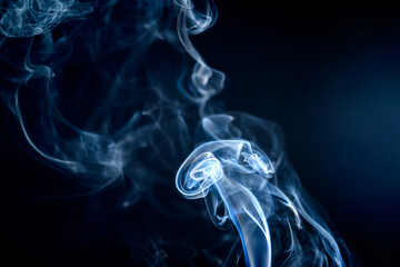 Fototapeta Falujący dym z kadzidełka unoszacy się w powietrzu na czarnym tle obraz