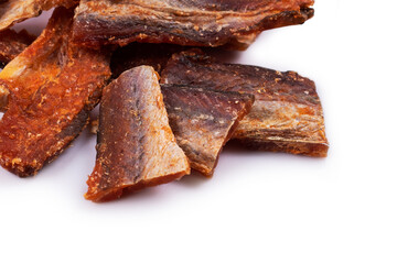 Pieces of cleaned dried fish isolated on white. Dry Peppered Pollack. Amber with pepper