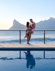 couple man and women in front of Infinity pool looking out over the ocean of Cape Town South Africa, man and woman in a swimming pool during vacation