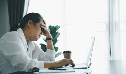 Feeling tired and stressed young women person of working age is working on wooden table in office. Professional businesswoman sleepy, depressed from overwork. Female employee feeling anxious at work.