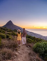 Photo sur Plexiglas Montagne de la Table A couple of men and women watching the sunset at Lion's Head near Table Mountain Cape Town South Africa