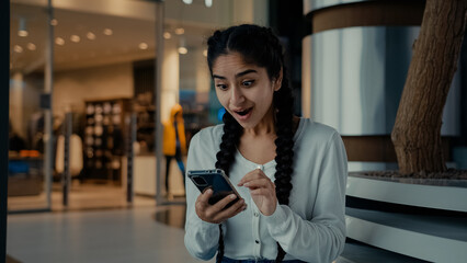 Emotional amazed winner arabian woman shopper use smartphone apps shopping online click on mobile...