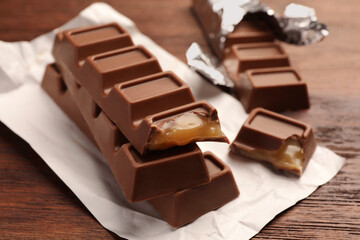 Tasty sweet chocolate bars on wooden table, closeup