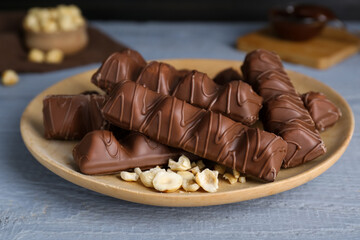 Sweet tasty chocolate bars with nuts on grey wooden table