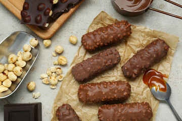Tasty chocolate bars with caramel and nuts on light table, flat lay