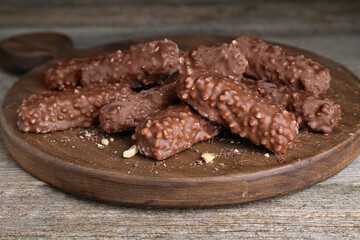 Tasty sweet chocolate bars on wooden table, closeup