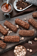 Fototapeta na wymiar Tasty chocolate bars with caramel and nuts on wooden table, flat lay