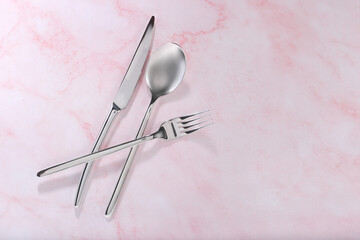 Stylish cutlery set on pink marble table, flat lay. Space for text