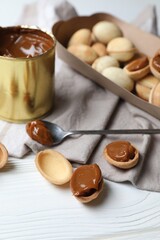 Delicious walnut shaped cookies with condensed milk on white wooden table, closeup