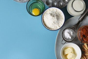 Baking mold and ingredients for walnut shaped cookies on light blue table, flat lay. Space for text