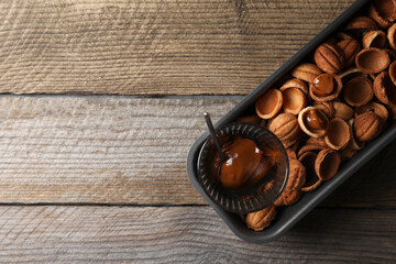 Making walnut shaped cookies. Cooked dough and caramelized condensed milk on wooden table, top view. Space for text