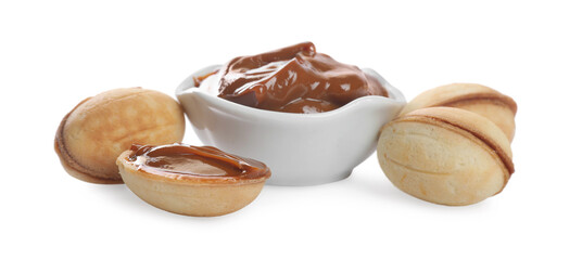 Walnut shaped cookies and bowl with boiled condensed milk on white background