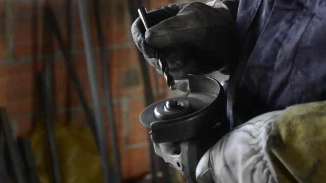 The master uses a grinder to sharpen the drill bit and you can see the sparks