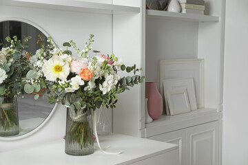 Bouquet of beautiful flowers on white table near mirror indoors. Space for text