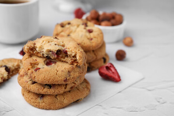 Cookies with freeze dried fruits and nuts on white textured table, closeup. Space for text