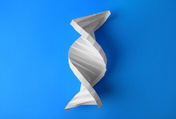 Paper model of DNA molecular chain on light blue background, top view