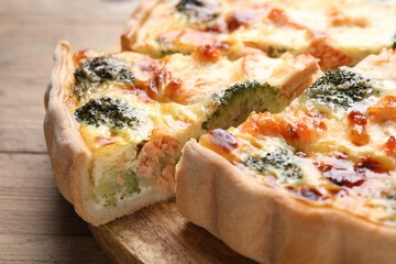 Delicious homemade quiche with salmon and broccoli on table, closeup