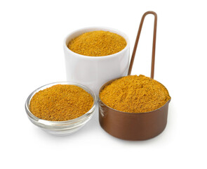 Glass, bowl and scoop with curry powder on white background