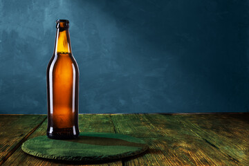 Brown glass bottle. The bottle is on a tray on the table. Blue background. Copy space.