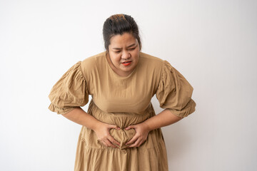 Young Asian plus size woman hand on stomach because nausea, painful disease feeling unwell,  may...