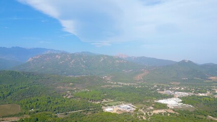 Fototapeta na wymiar Splendid Skyward Perspective: Lecci, Corsica - Foggy Horizon Meets Sunny Peaks in an Idyllic Aerial Landscape