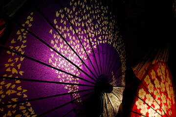 夜に浮かび上がる紫の和傘のイルミネーション